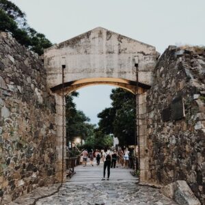 View through the historic gateway with stone walls and cobblestone street in Colonia del Sacramento, Uruguay.