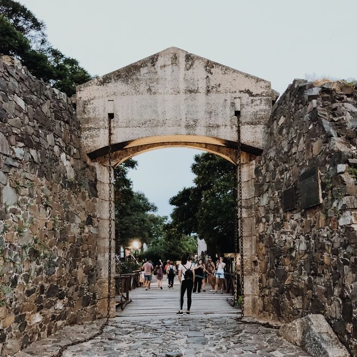 View through the historic gateway with stone walls and cobblestone street in Colonia del Sacramento, Uruguay.